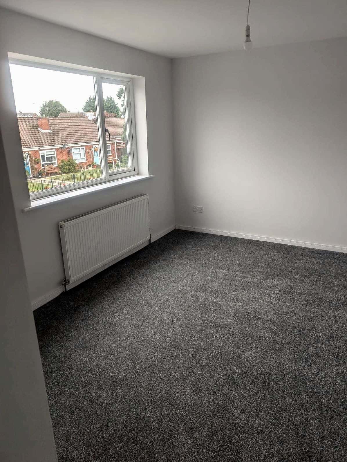 Bedroom finished: fresh walls, new grey carpet and a radiator under the window