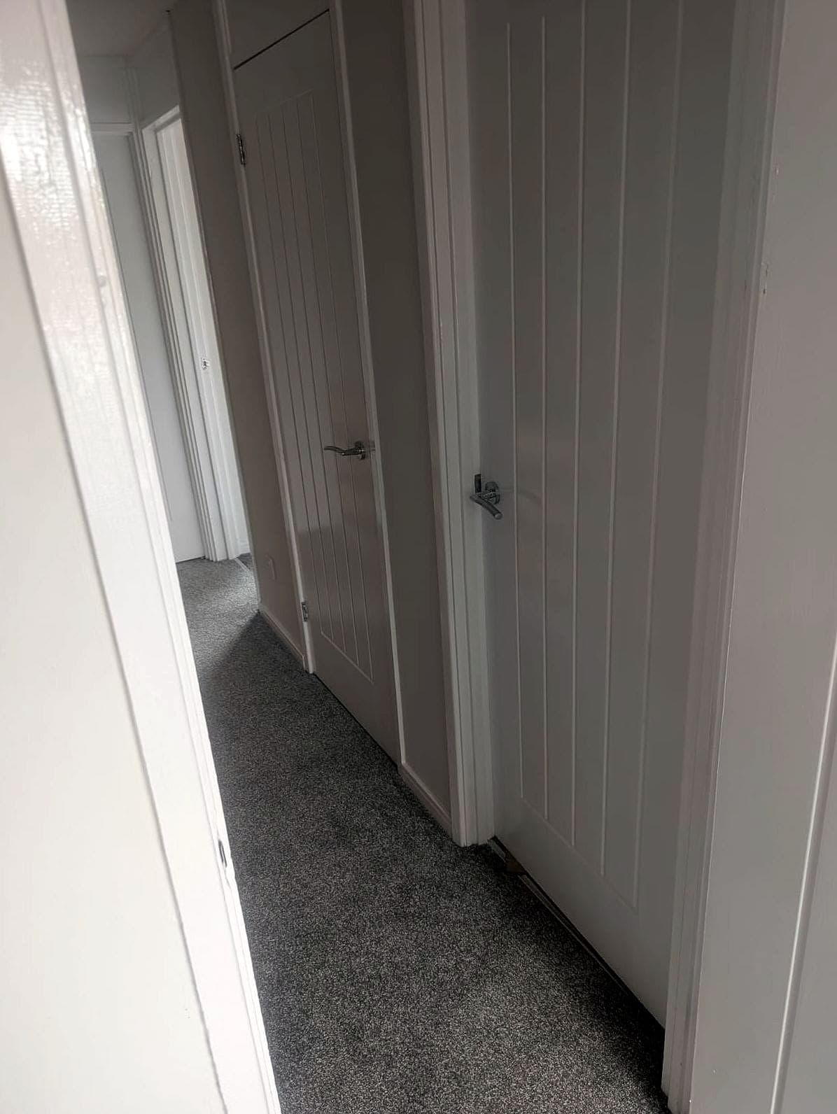 Landing with new white panelled doors and grey carpet
