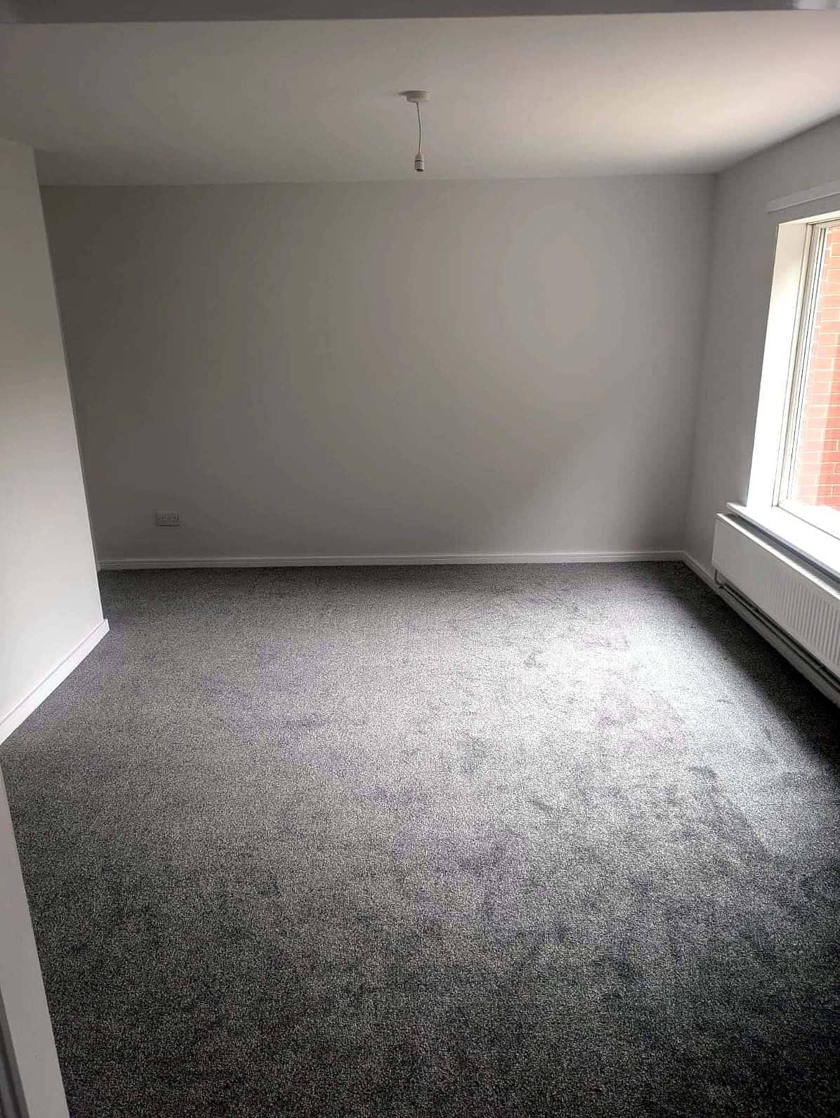 Living room finished: fresh walls and new grey carpet