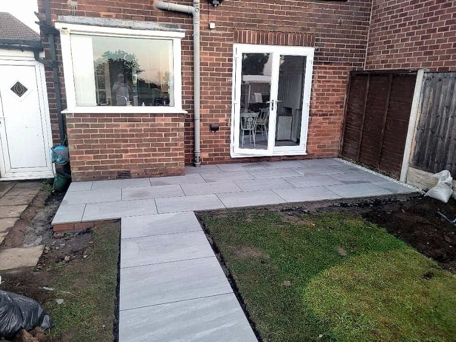 Rear patio and path laid in large pale porcelain slabs