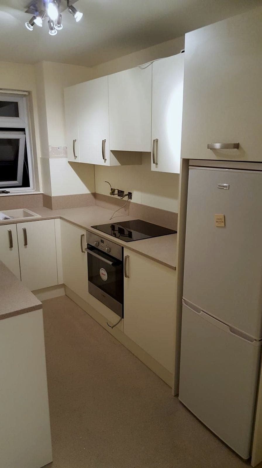 Compact kitchen with a built-in oven, hob, fridge freezer and cream units