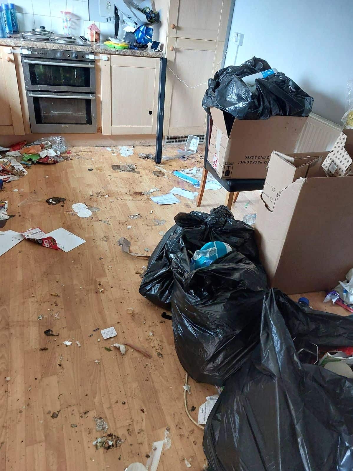 Kitchen as found: bin bags, boxes and rubbish across the floor
