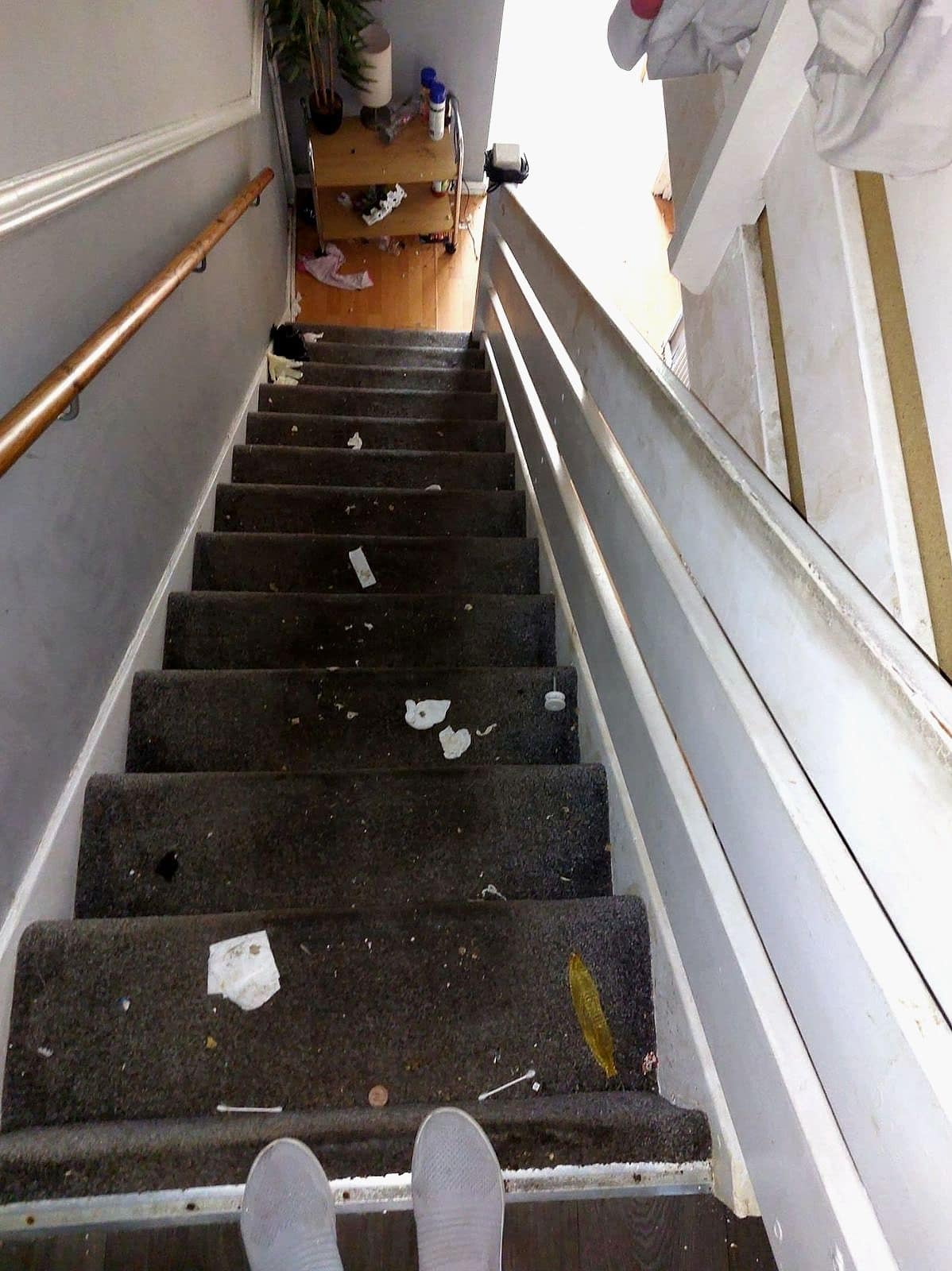 Looking down the stairs as found, with rubbish on the treads