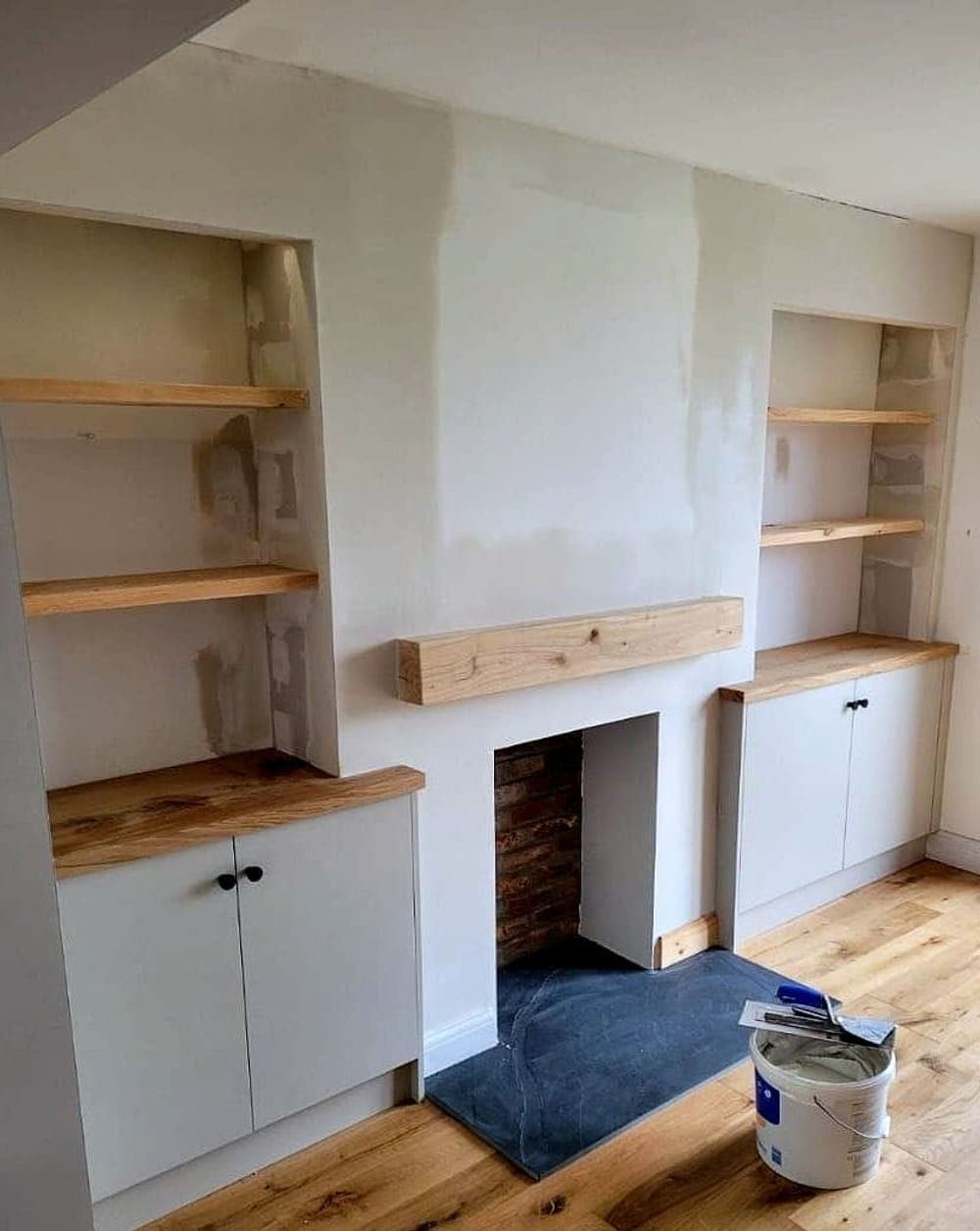 Alcove cupboards and oak shelves fitted, fresh plaster on the chimney breast